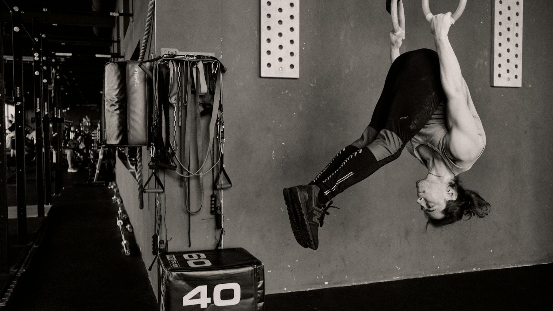 Athletic man performing strength exercises in a moody gym environment